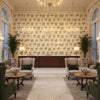 WOODLAND Fabrics (AF57853) – Green on Natural | Thibaut - Hotel Lobby Visualization (AI-generated, may not be to scale. Verify pattern scale with product specifications.)